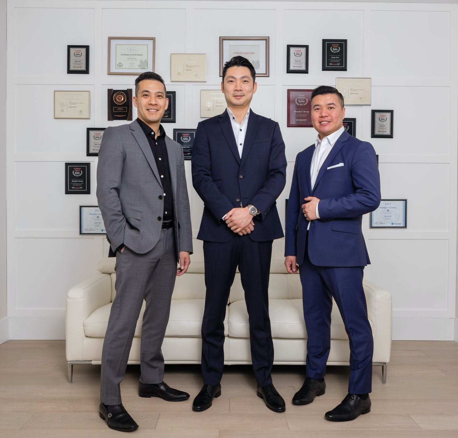 Randal Cheng, Jason Fan and Tony Tran — founders of The Key Agents — in front of their awards wall